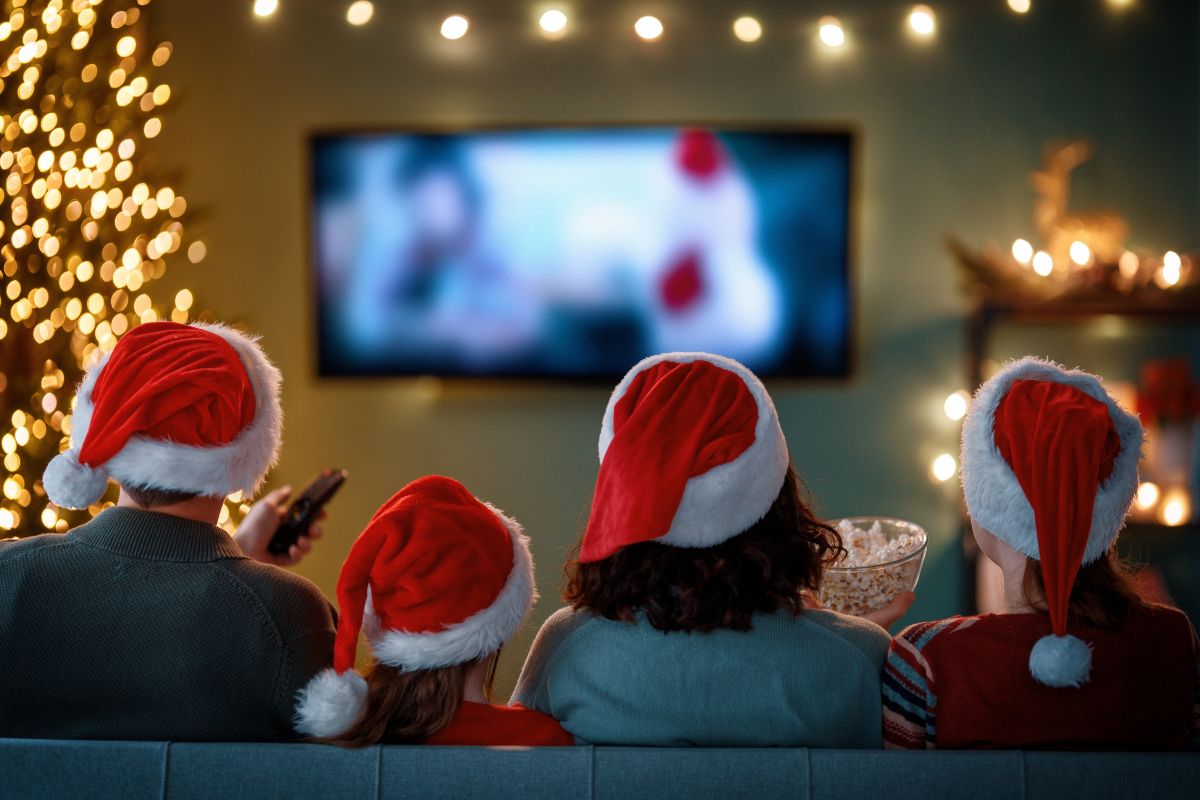 Una famiglia con i cappelli di Babbo Natale vede un film