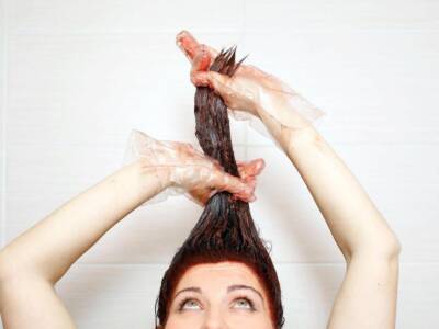 Donna che applica la tinta per capelli.