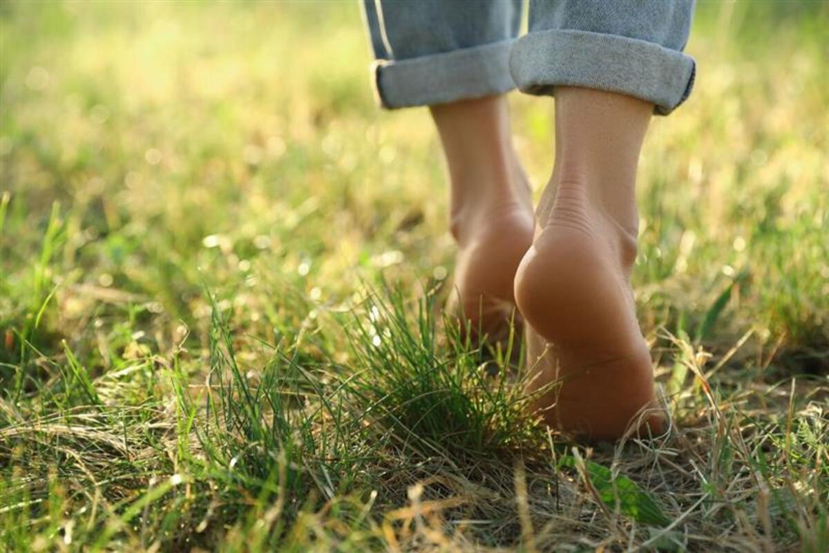 Donna passeggia scalza sull'erba