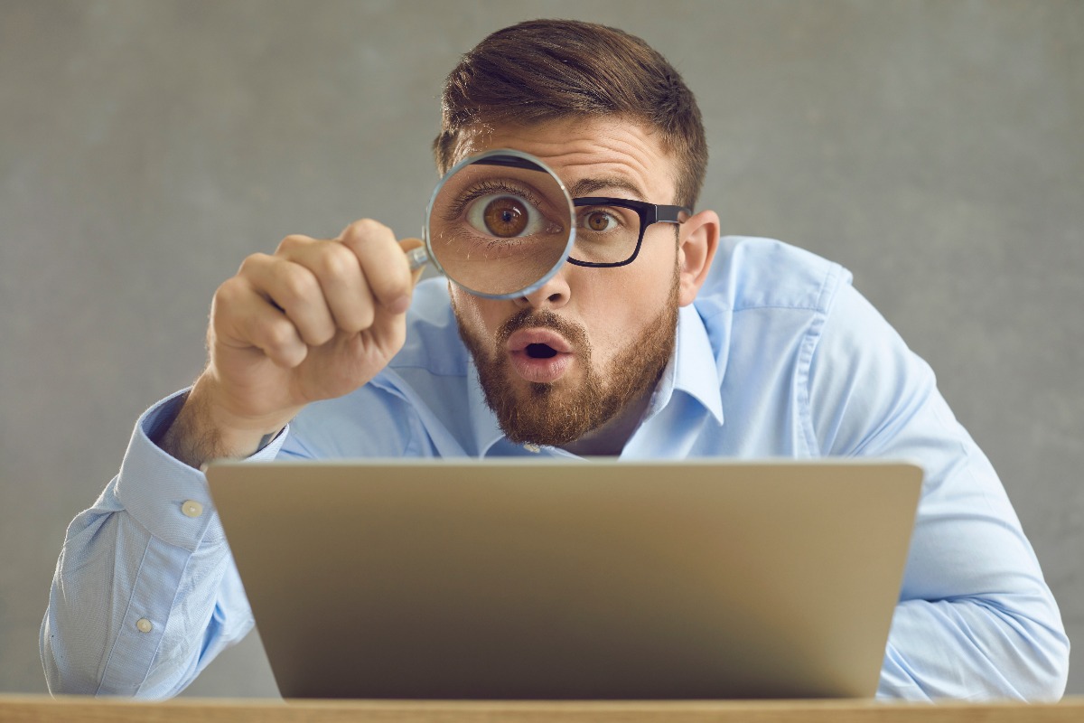 Ragazzo guarda attraverso la lente il suo pc